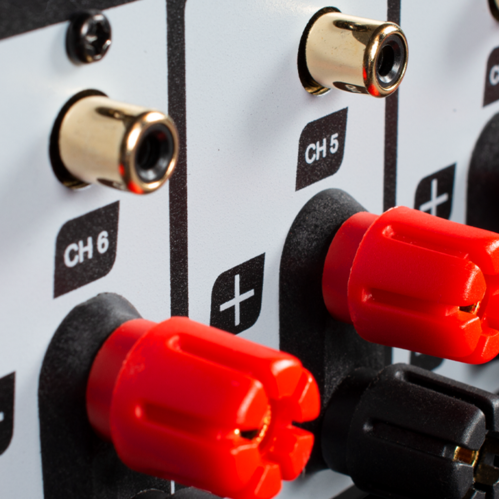 Close-up of an amplifier with red knobs on a black background