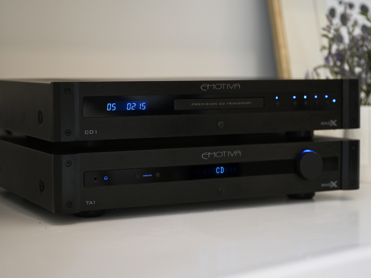 A Photo of the BasX CD1 CD Player and the BasX TA1 Stereo Preamp on a white cabinet