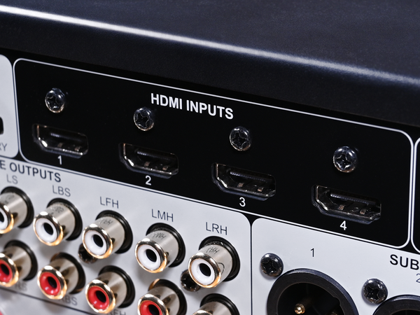 Close-up of the rear panel of an audio receiver or amplifier, showing four HDMI input ports labeled 1 through 4, with audio output RCA jacks and other connectors below.